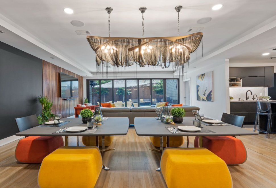 Contemporary luxury dining room interior design with statement chandelier, custom furniture, open living space, and modern finishes by Spotlight Style Houston