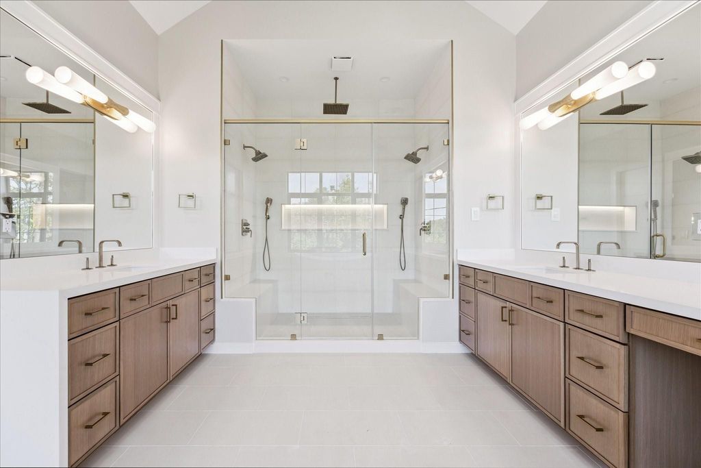 Luxury modern bathroom interior design with double vanity, glass shower enclosure, custom cabinetry, and elegant finishes by Spotlight Style Houston