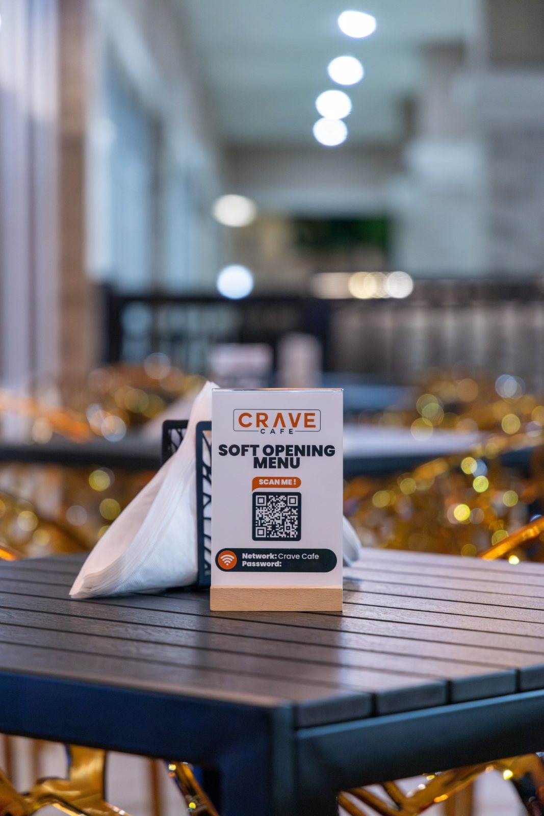 Crave Café — An evening shot of the patio tabletop, the branded menu card lit against soft bokeh.