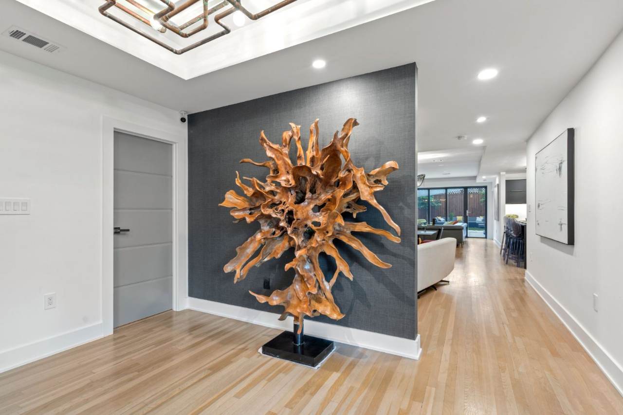 River Oaks Transformation — Statement entry with sculptural art against a charcoal wall