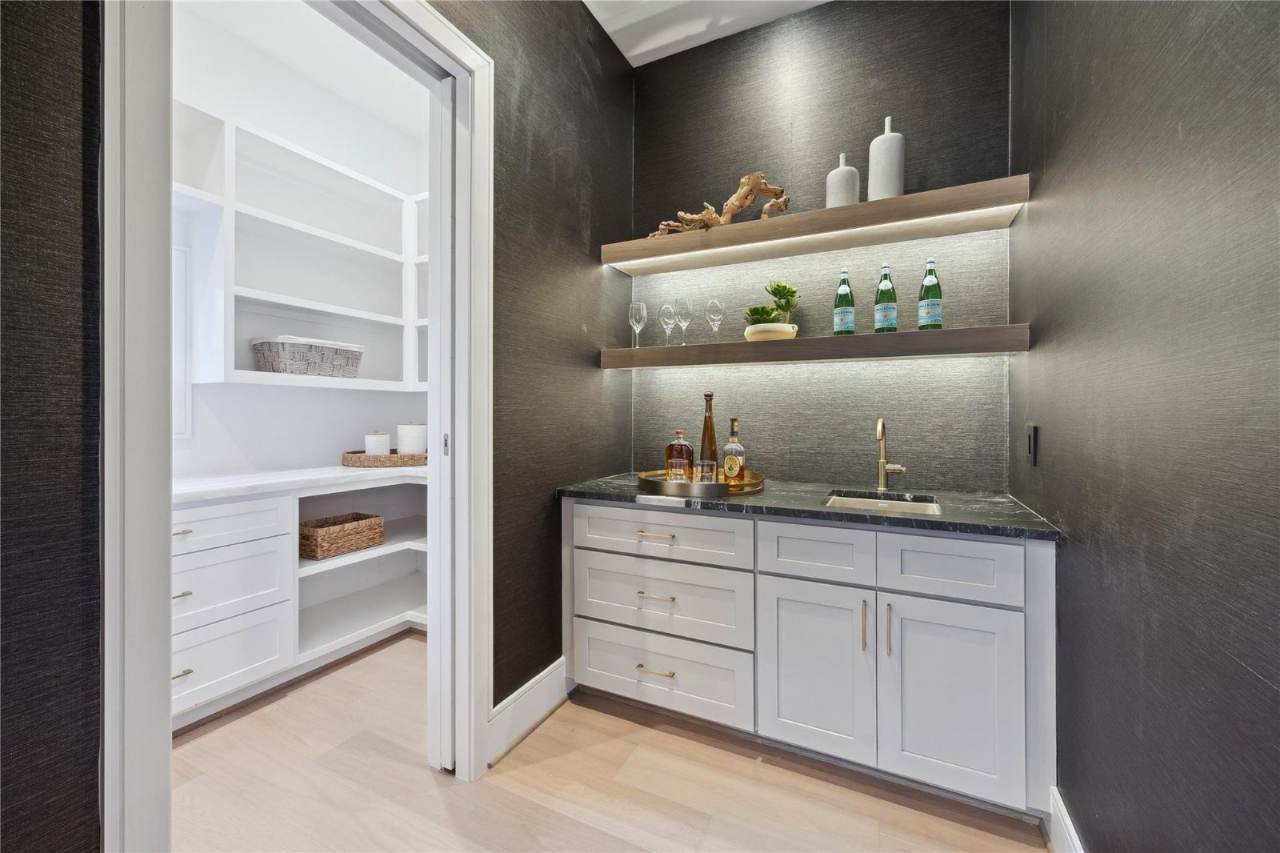 West University Custom Home — Richly textured wet bar with floating shelves and brass fixtures