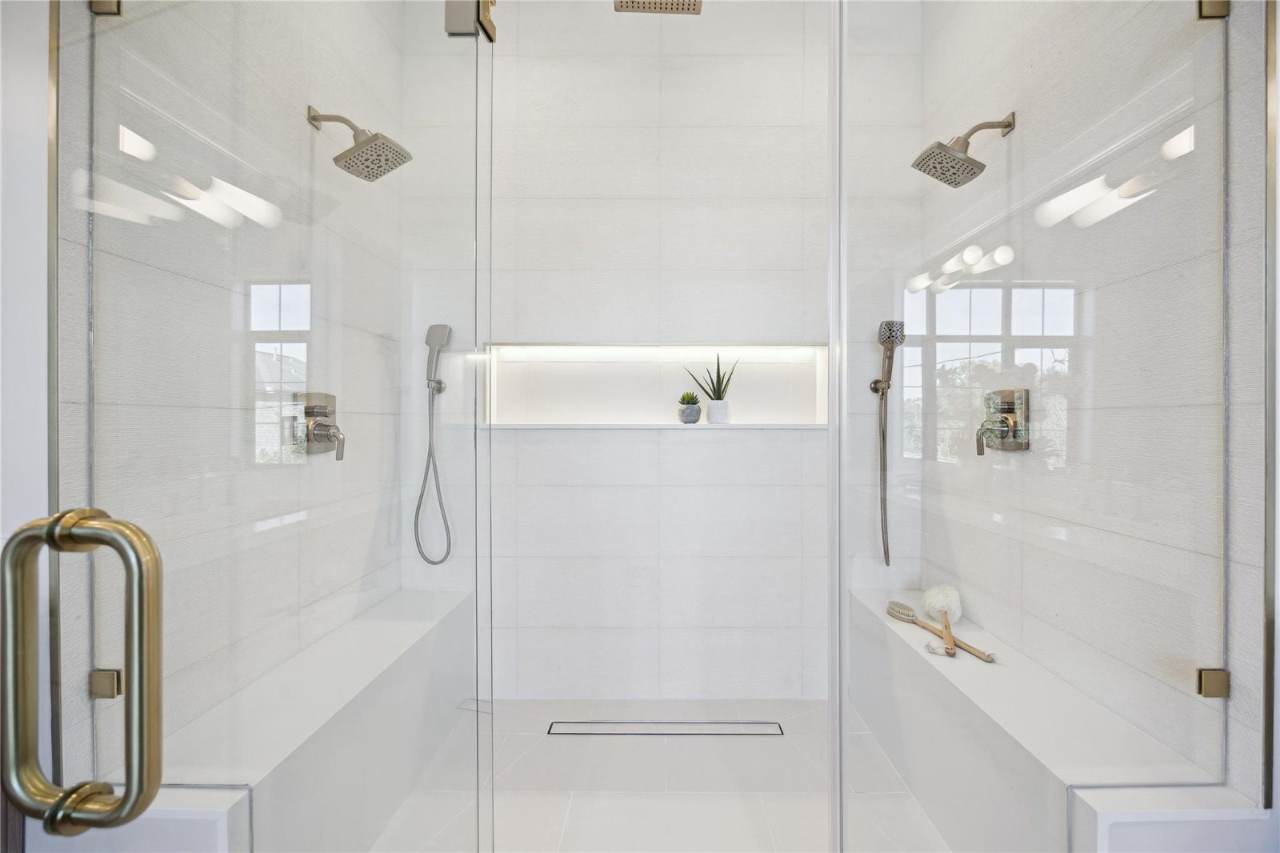 West University Custom Home — Dual-head walk-in shower with a backlit niche