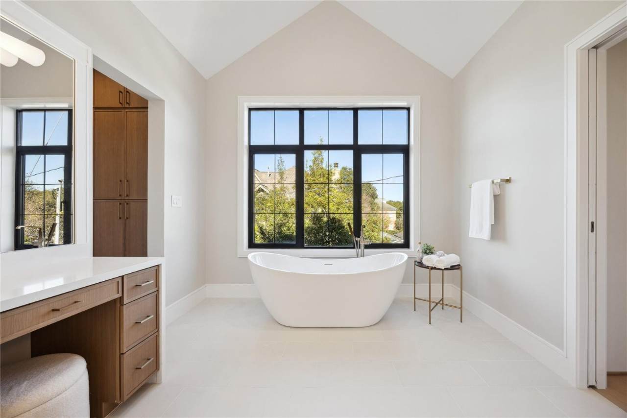 West University Custom Home — Primary bath with freestanding soaking tub and steel-framed window