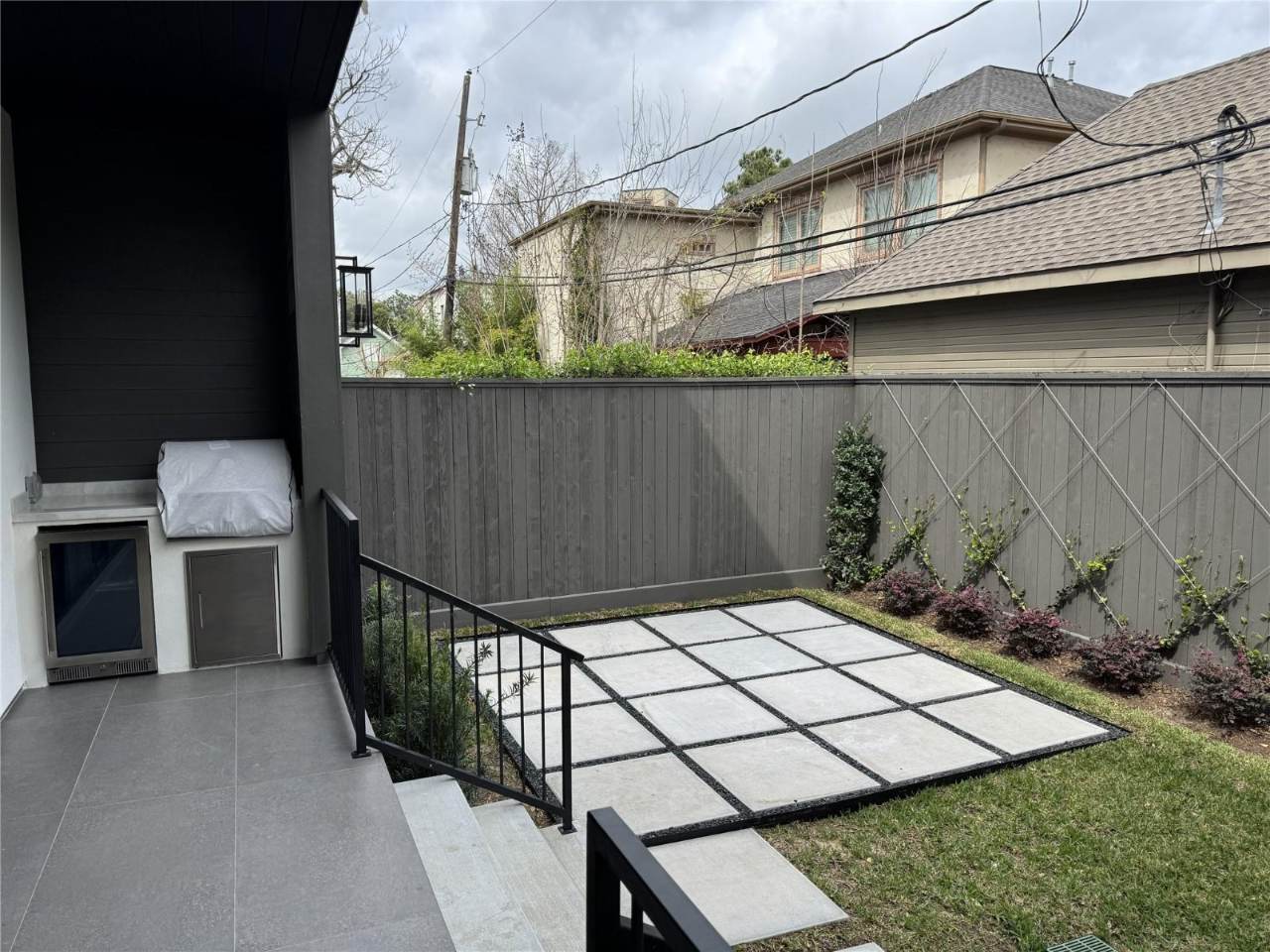 West University Custom Home — Outdoor terrace with built-in grill and landscaped yard